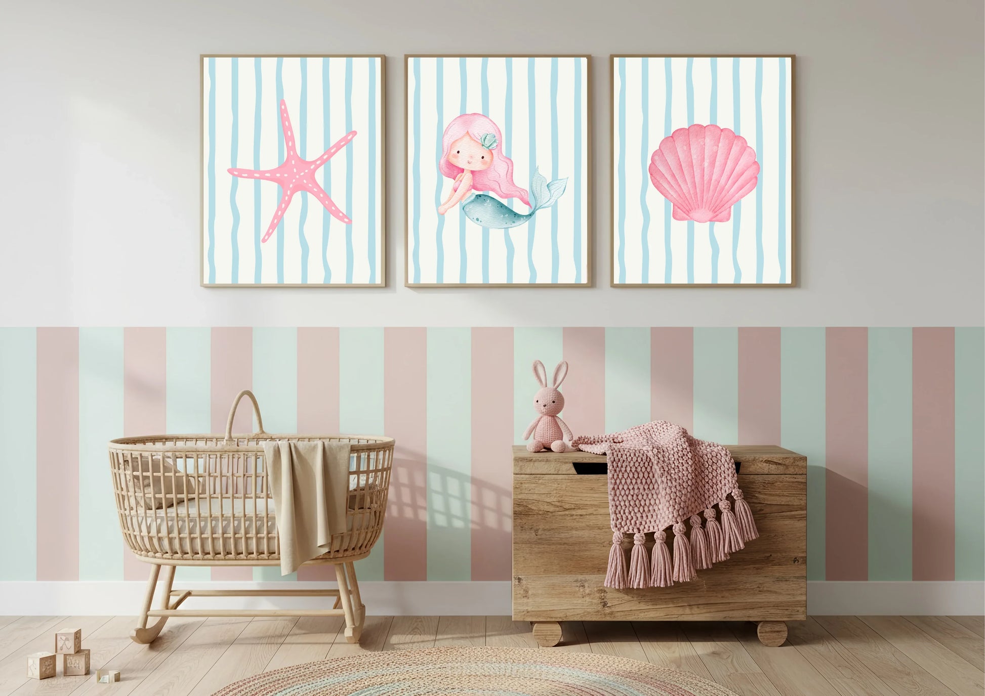 Nursery room with wall art featuring a mermaid, starfish, and shell on a striped background.