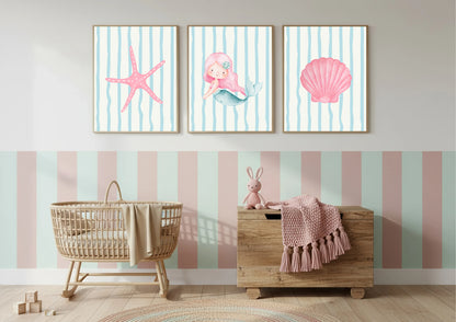 Nursery room with wall art featuring a mermaid, starfish, and shell on a striped background.