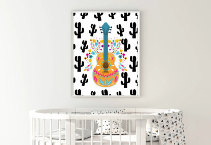 
A framed boho folk art guitar print with a black cactus background, hanging on a white wall above a white wooden crib.