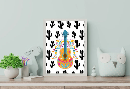 A framed boho folk art guitar print with a black cactus background, standing on a light wooden dresser between a toy dinosaur and a plush owl.