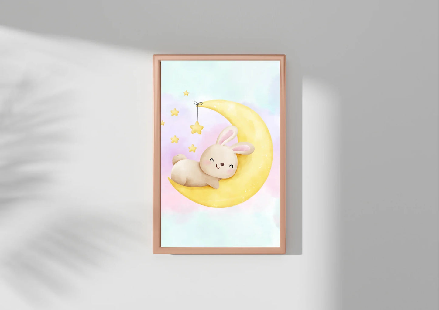 Framed artwork of a cartoon bunny on a moon with stars against a light gray background