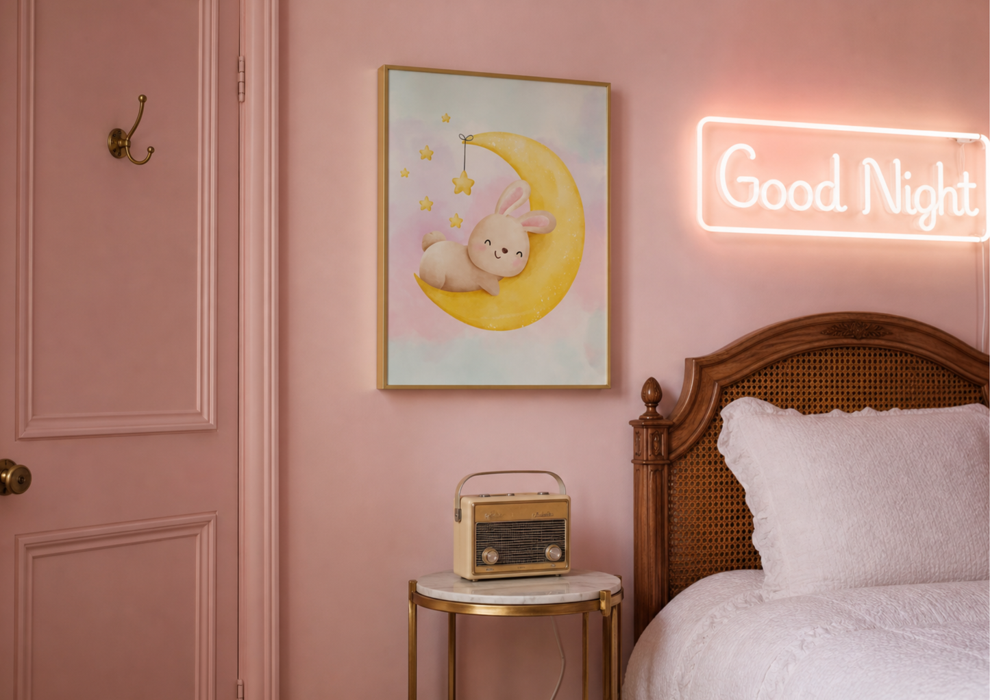 A styled bedroom corner with a pink wall, a framed pastel artwork of a bunny on a crescent moon, a glowing neon 'Good Night' sign, a wooden bed with white bedding, and a small side table with a vintage radio.