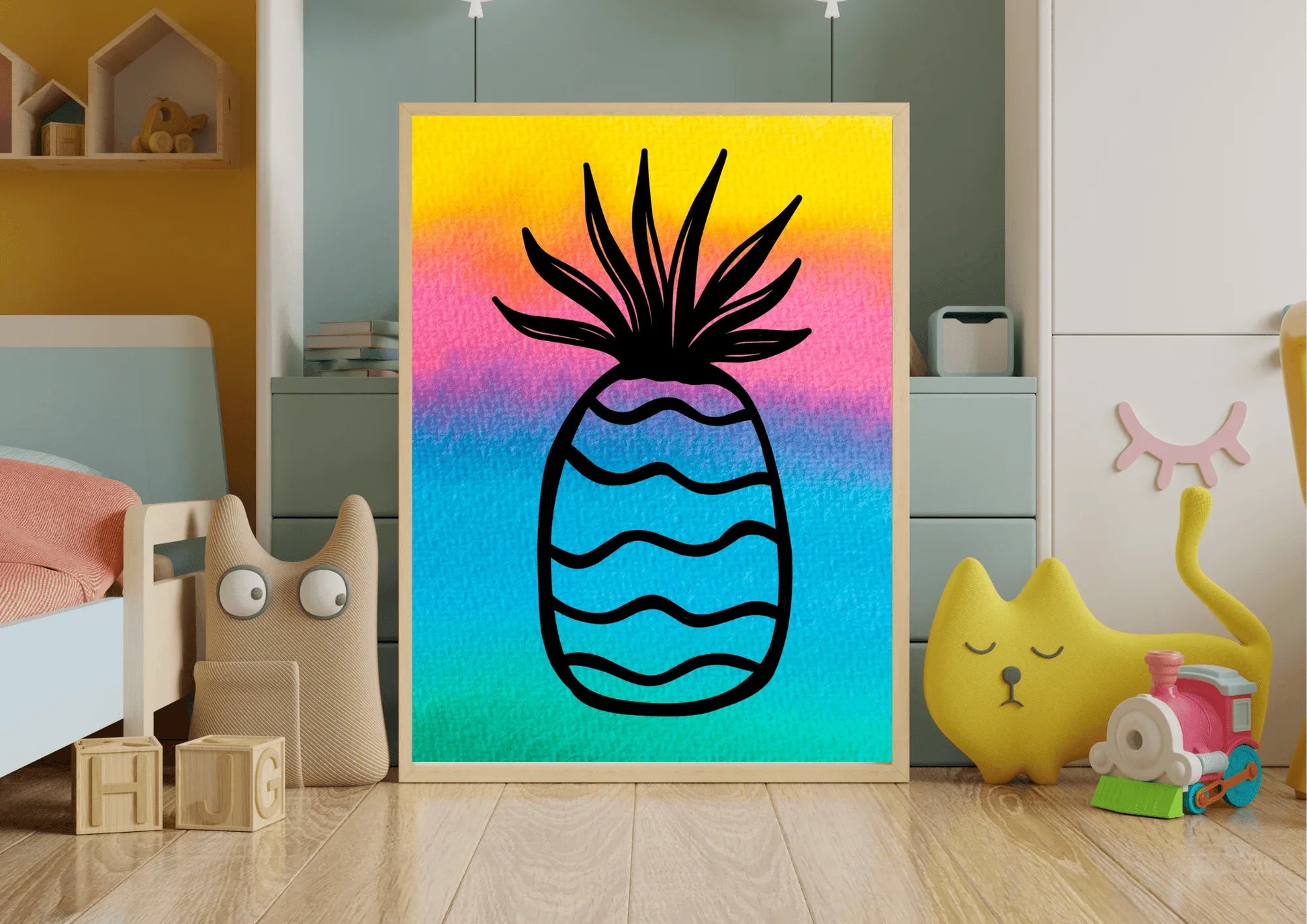 Close-up of a framed watercolor pineapple print with a bright yellow, pink, and blue background, positioned on the wooden floor of a playful child's bedroom alongside toys.
