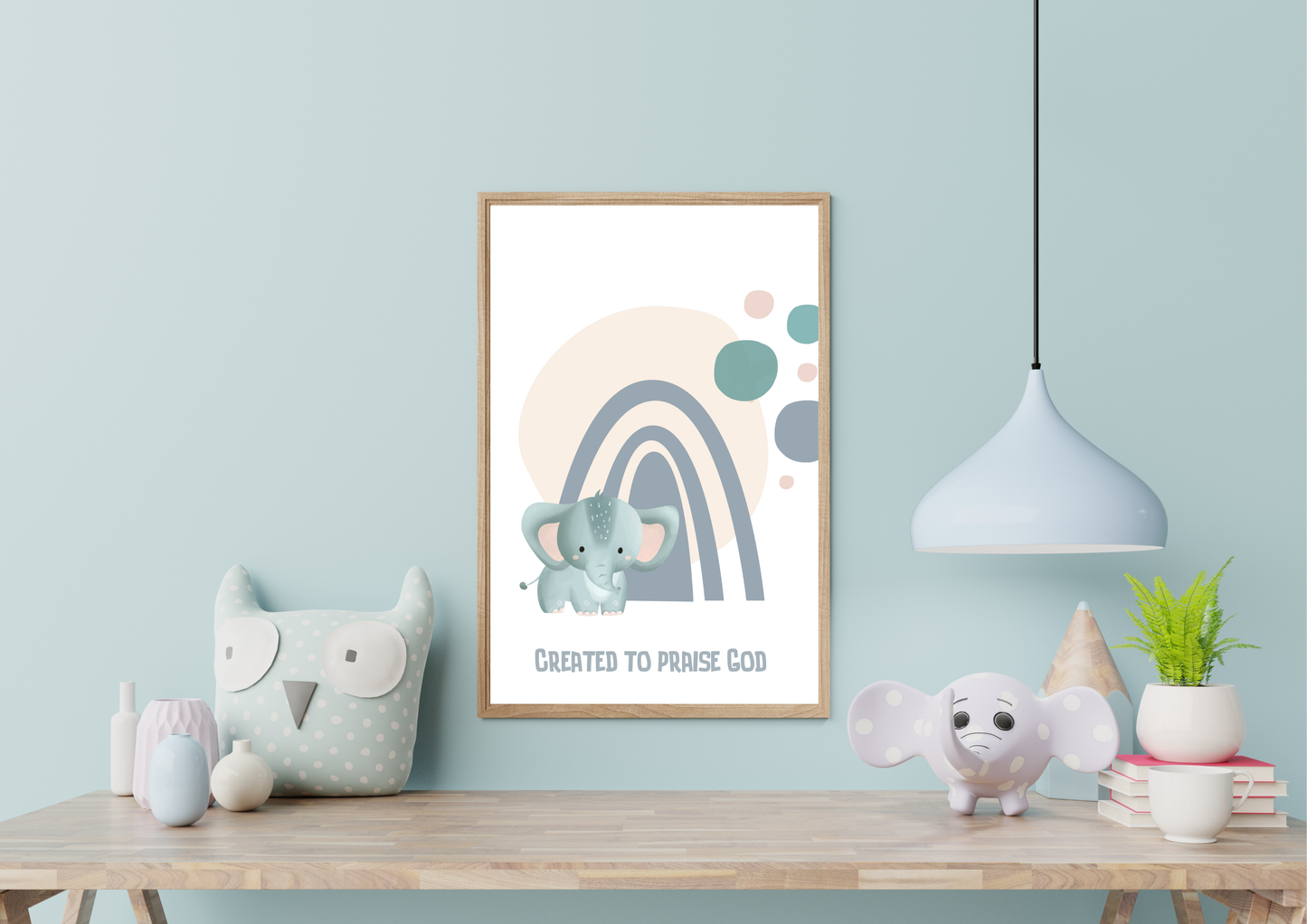 Framed artwork with a cartoon elephant and rainbow on a wall above a wooden shelf with decorative items.