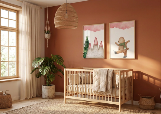 Two framed watercolor winter bear art prints hanging above a light-wood spindle crib in a warm terracotta nursery.