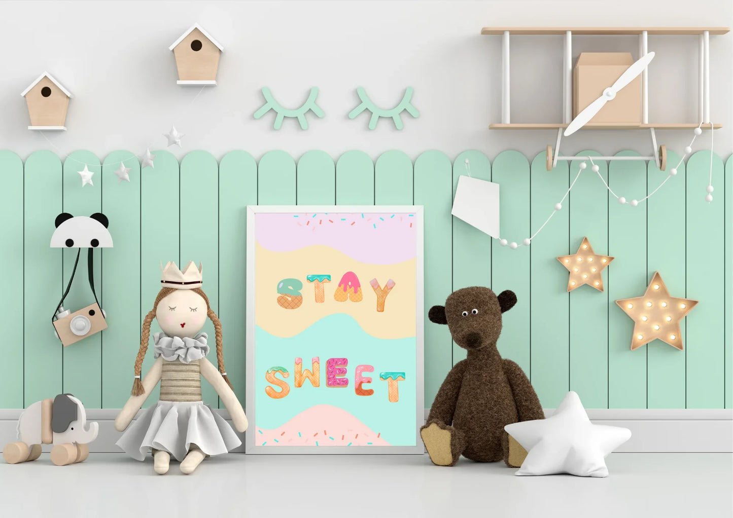 Children's room with toys, a poster, and decorative items on a mint green wall.