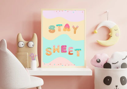 Children's room decor with a 'Stay Sweet' poster, plush toys, and a pink wall.