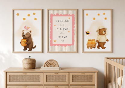 Nursery room with framed illustrations of bears and text on a wall above a wooden dresser.