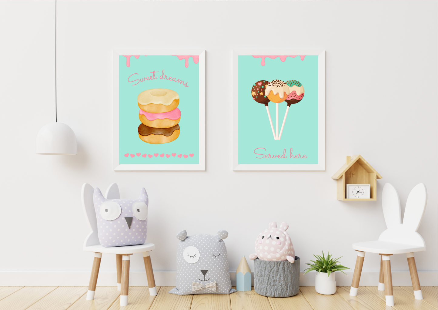 A set of two framed art prints of donuts and cake pops on a white wall in a playroom with animal-themed chairs.