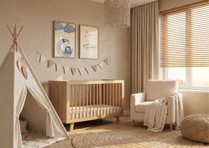 A serene, monochromatic boho nursery in warm beige and cream tones. On the left, a cream canvas play teepee stands next to a modern light-wood crib with vertical spindles. Above the crib, two wooden-framed art prints are displayed—one of a whimsical elephant sleeping on a moon and another with "sweet dreams" in blue script—accented by a neutral fabric bunting hanging below them. To the right, a plush cream armchair with a chunky knit throw sits near a large window with wooden blinds, while a round jute rug 