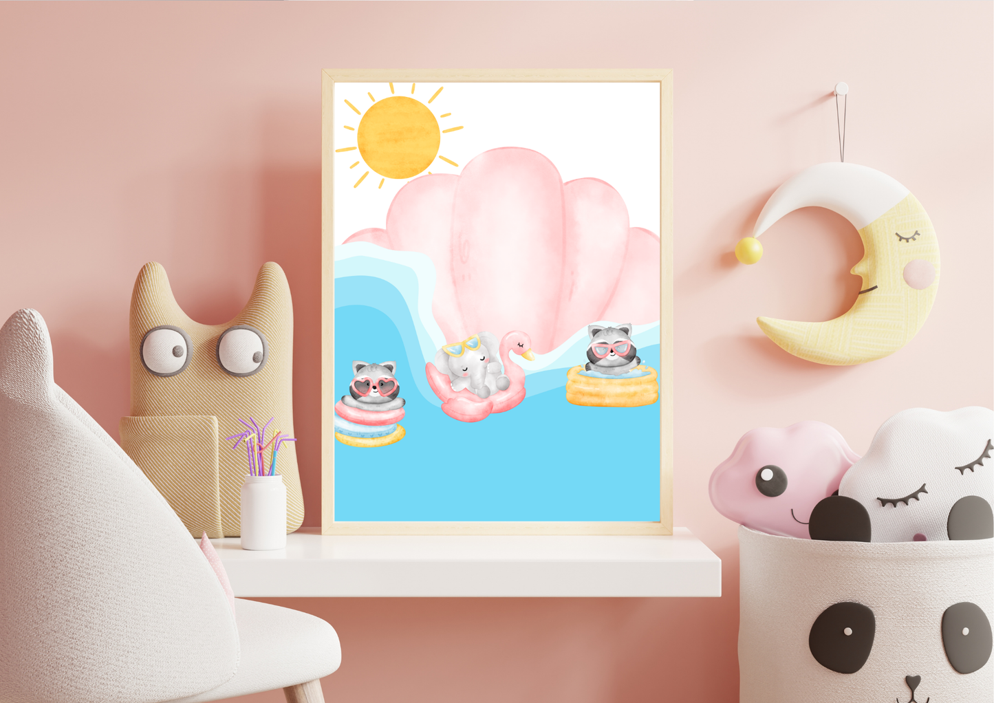 Pink-themed nursery shelf display featuring a framed print of raccoons and an elephant floating in pool tubes, with a hanging yellow crescent moon and a woven panda storage basket filled with pillows.