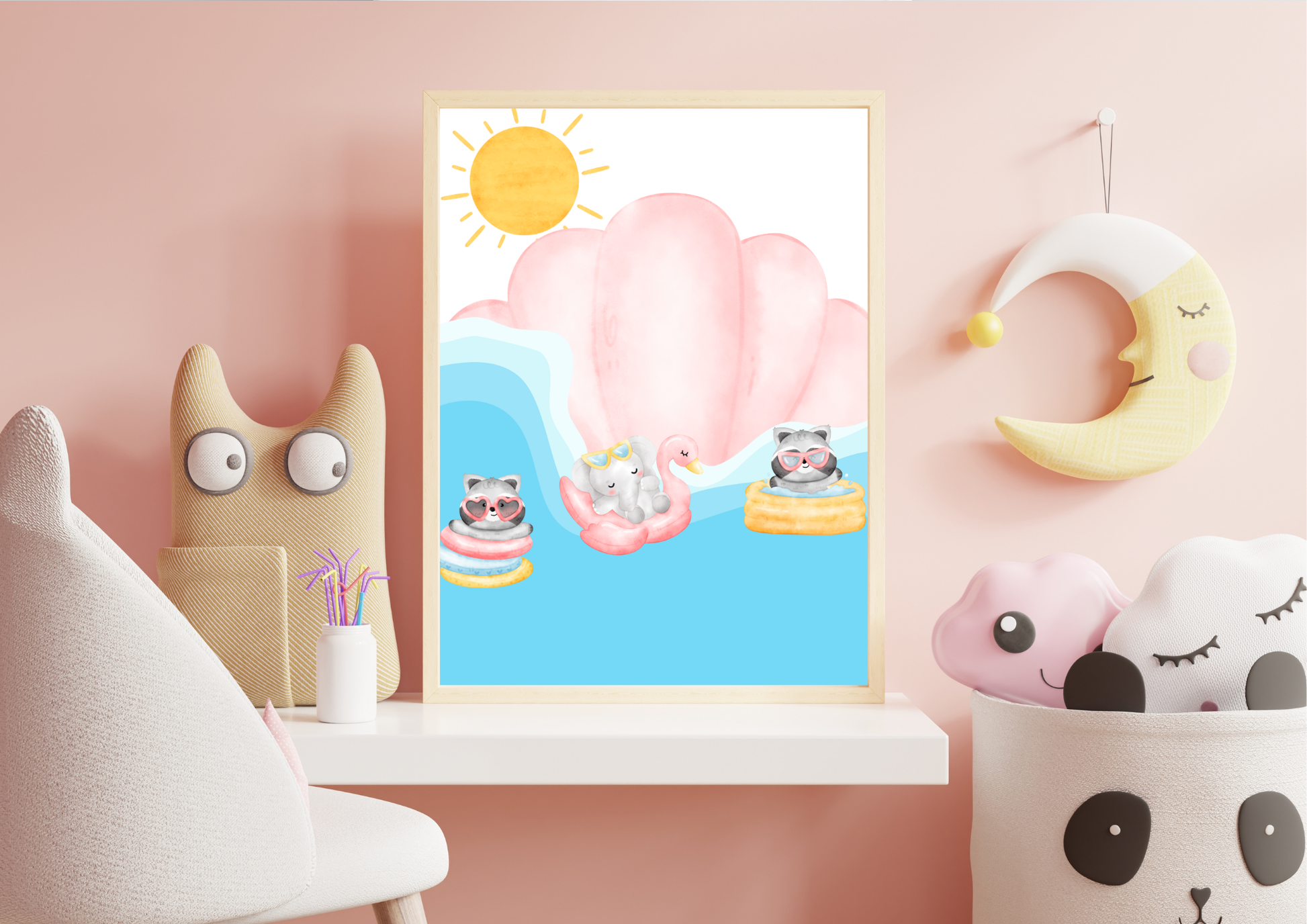Pink-themed nursery shelf display featuring a framed print of raccoons and an elephant floating in pool tubes, with a hanging yellow crescent moon and a woven panda storage basket filled with pillows.
