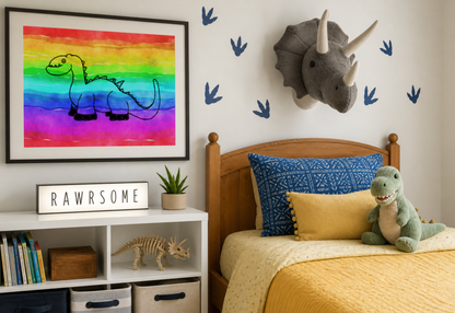 A framed wall art print featuring a black line drawing of a long-neck dinosaur on a bright rainbow watercolor background, displayed in a styled children's bedroom above a bed with dinosaur-themed decor.