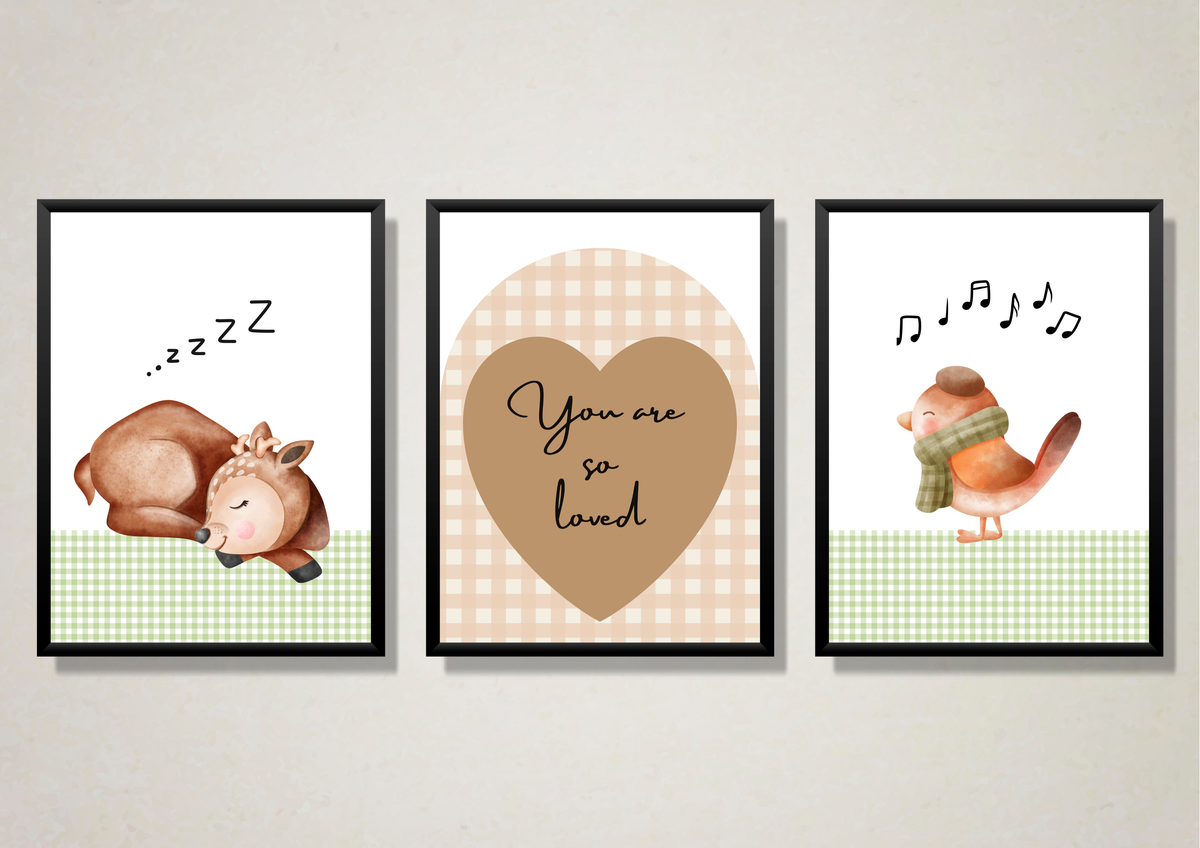 Three framed wall art prints hanging side by side on a light beige wall. The left print shows a sleeping brown animal with 'zzz' text above it on a white and green gingham background.