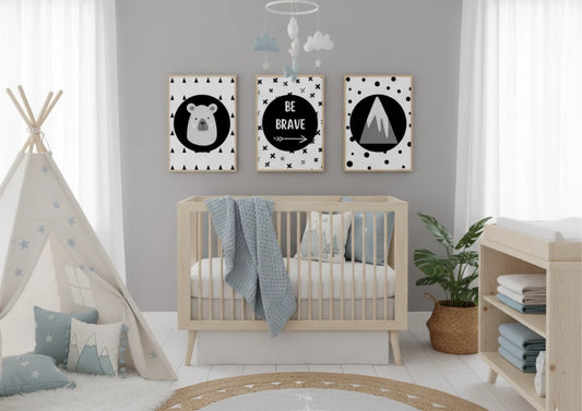 Three monochrome nursery prints featuring a bear, "Be Brave" text, and a mountain, hanging above a wooden crib in a neutral-toned nursery with a teepee and plants.