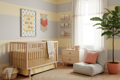 A gender-neutral nursery with walls featuring horizontal stripes of pastel yellow and gray. The framed I Am With You Always Christian art hangs above a natural wood crib. The room includes a low gray armchair, a light wood dresser, a large round jute rug, a terracotta and cream macrame wall hanging, and wooden floating shelves.