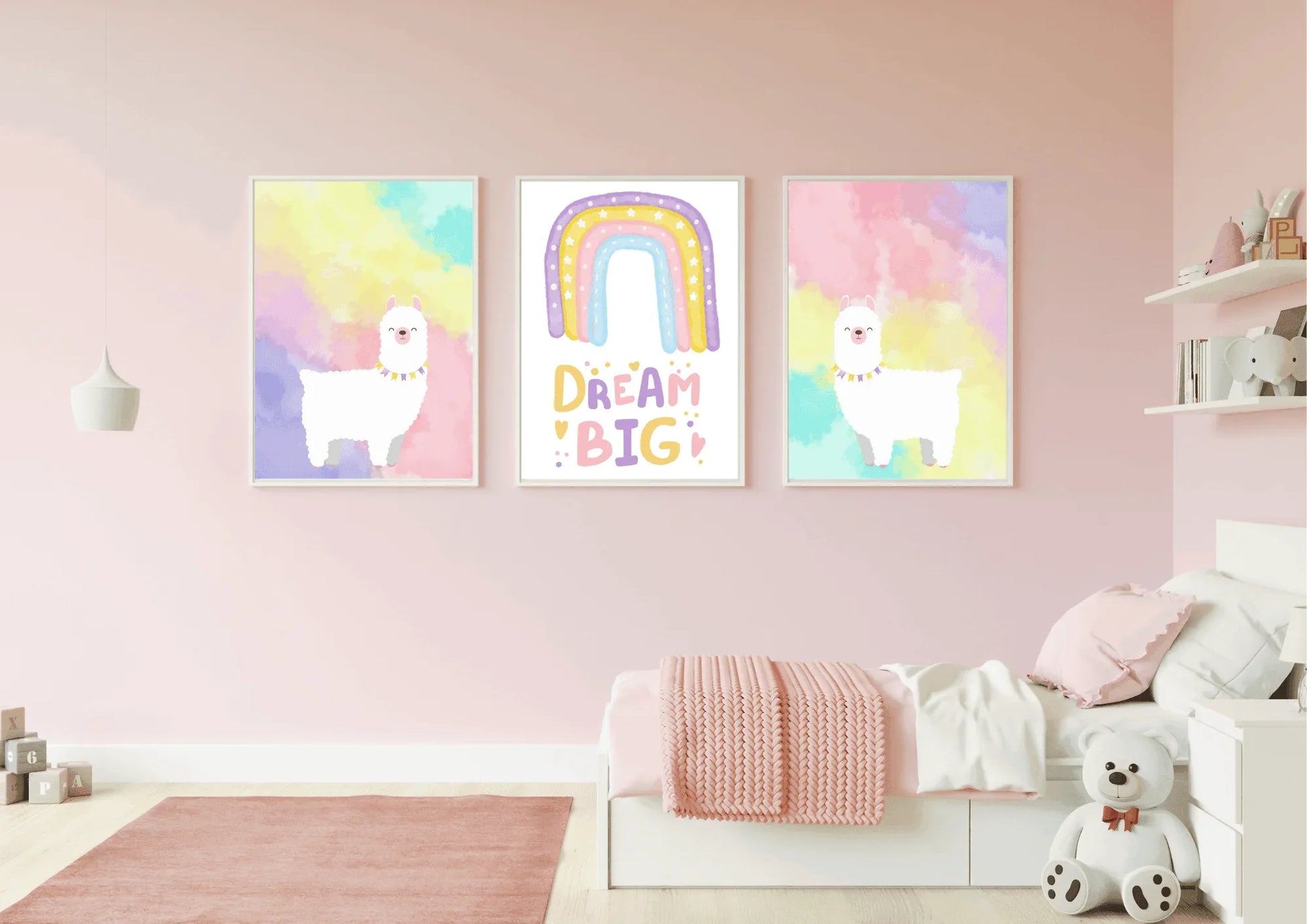 A set of three framed art prints with two llamas and a "Dream Big" quote on a pink wall in a child's bedroom.
