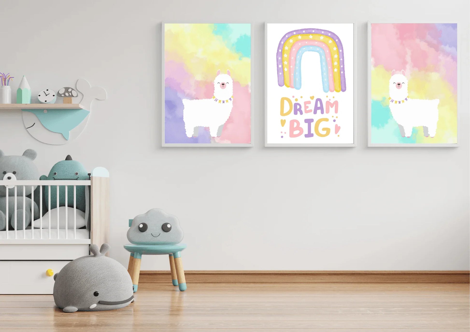 A set of three framed art prints with two llamas and a "Dream Big" quote on a white wall in a child's playroom with a crib and toys.