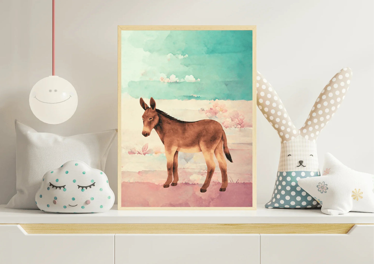 Framed artwork of a donkey on a shelf with decorative pillows and a lamp.